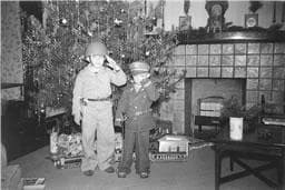 Walter Carter and his older brother, saluting their father in a 1943 Christmas photo. He would die less than 6 months later. (Courtesy)