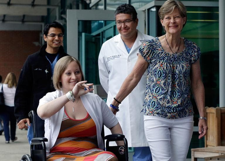 Erika Brannock, 29, a Baltimore-area preschool teacher who lost a leg in the Boston Marathon bombings, is accompanied by her mother, Carol Downing, right, as she is released from Beth Israel Deaconess Medical Center in Boston on Monday. (Elise Amendola/AP)