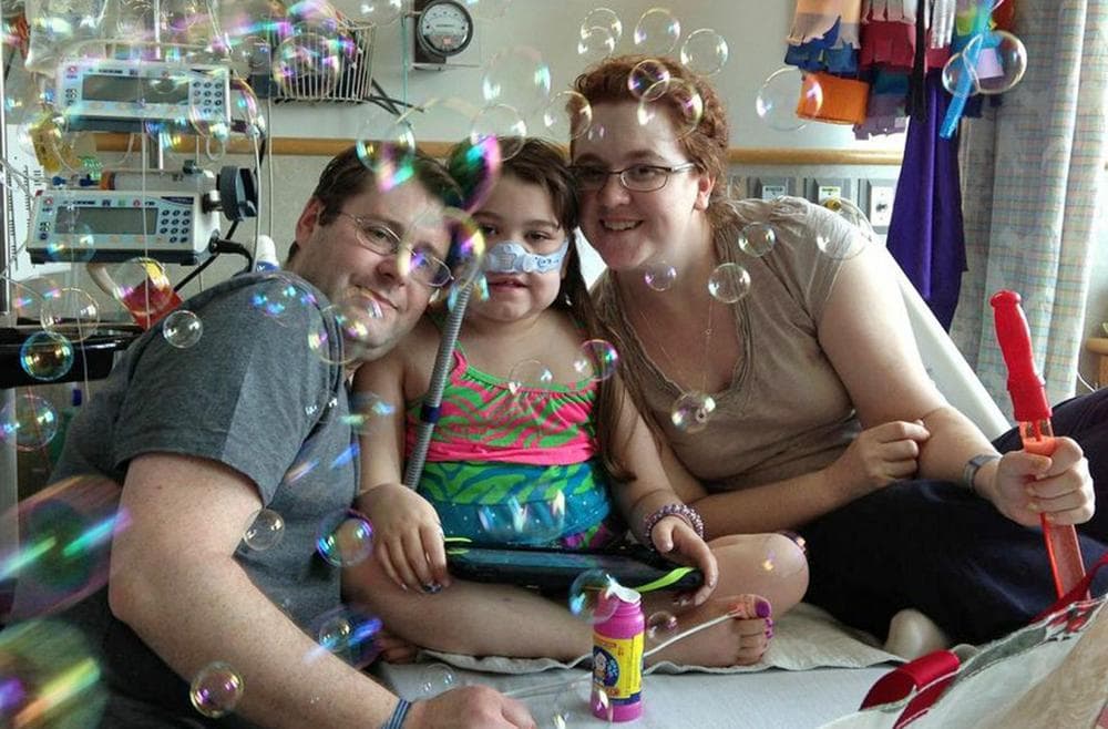 Sarah Murnaghan, center, celebrates the 100th day of her stay in Children's Hospital of Philadelphia with her father, Fran, left, and mother, Janet. (Courtesy of Murnaghan Family, via AP)