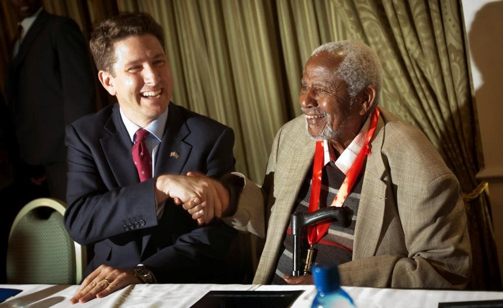 Secretary General of the Mau Mau War Veterans Association, Gitu wa Kahengeri, right, shakes hands with British High Commissioner to Kenya Christian Turner, left, at the start of a press conference announcing a settlement in the case by Mau Mau veterans for compensation against the British Government, in Nairobi, Kenya Thursday, June 6, 2013. (Ben Curtis/AP)