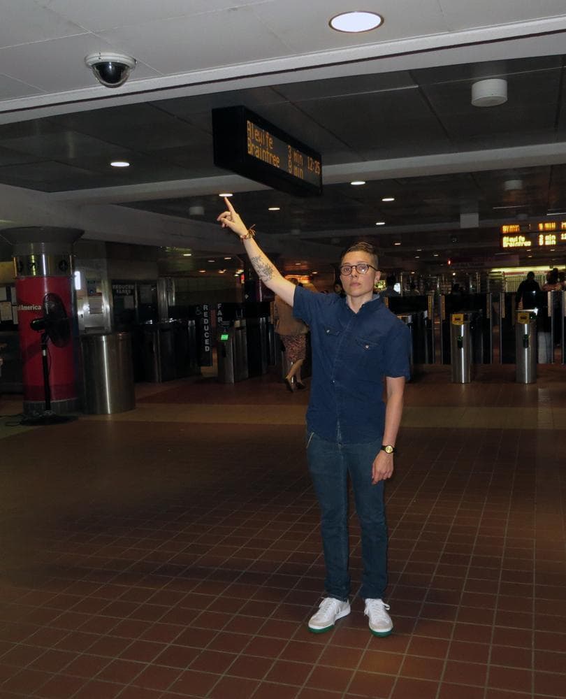 Kade Crockford of the ACLU of Massachusetts gestures toward a surveillance camera at an MBTA station. (Bruce Gellerman/WBUR)