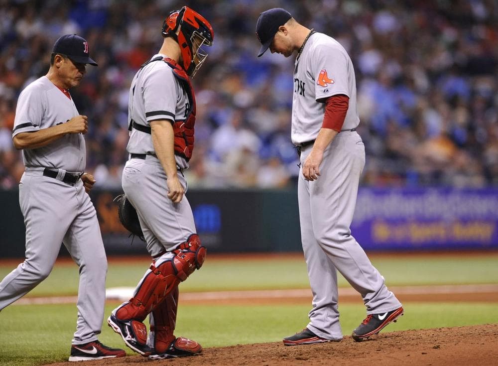 Red Sox pitching coach Juan Nieves, left, and catcher David Ross, center, come out to the mound to speak to starting pitcher Jon Lester during the fifth inning of a baseball game against the Tampa Bay Rays Tuesday, June 11, 2013, in St. Petersburg, Fla. (AP/Brian Blanco)