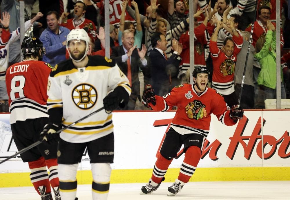 Chicago Blackhawks center Andrew Shaw, right, celebrates after scoring the winning goal during the third overtime period of Game 1 in their NHL Stanley Cup Final hockey series against the Boston Bruins, Thursday, June 13, 2013, in Chicago. (Nam Y. Huh/AP)
