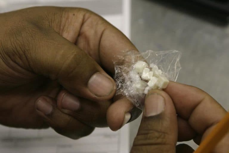 In this Oct. 10, 2006 file photo, a Los Angeles police officer counts the number of doses of crack cocaine, as he files an evidence police report after a drug related arrest. (Damian Dovarganes/AP)