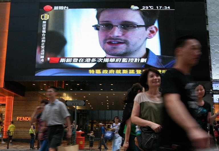 A TV screen shows a news report of Edward Snowden, a former CIA employee who leaked top-secret documents about sweeping U.S. surveillance programs, at a shopping mall in Hong Kong Sunday, June 23, 2013. The former National Security Agency contractor wanted by the United States for revealing two highly classified surveillance programs has been allowed to leave for a &quot;third country&quot; because a U.S. extradition request did not fully comply with Hong Kong law, the territory's government said Sunday. (Vincent Yu/AP)