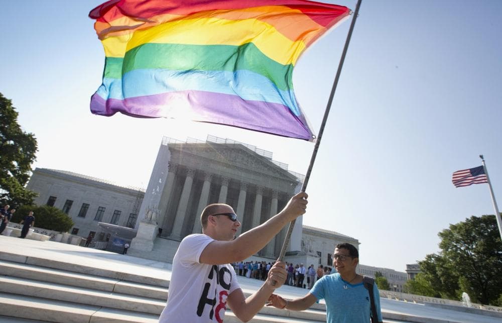Vin Testa of Washington waves a rainbow flag in support of gay rights outside the Supreme Court in Washington, Tuesday, June 25, 2013, as key decisions are expected to be announced. (J. Scott Applewhite/AP)