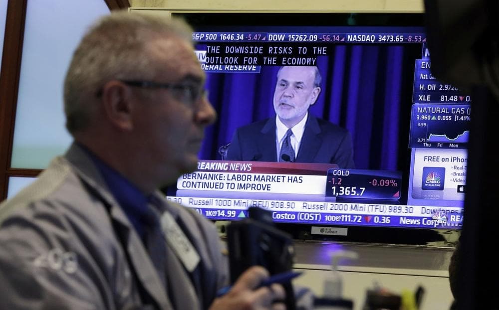 Fed Chairman Ben Bernanke is on a television screen as trader James Dresch works in a booth on the floor of the New York Stock Exchange Wednesday, June 19, 2013. (Richard Drew/AP)