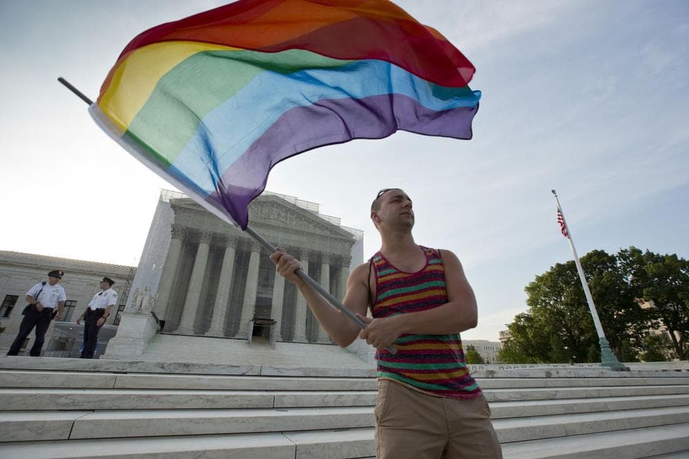 Gay rights advocate Vin Testa waves a rainbow flag in front of the Supreme Court at sun up  on Wednesday (J. Scott Applewhite/ AP)