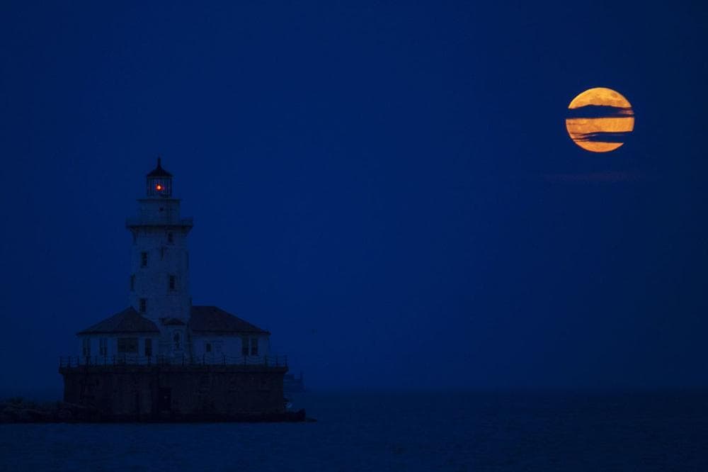 The moon rises next to the Chicago Harbor Lighthouse. (Scott Eisen/ AP)