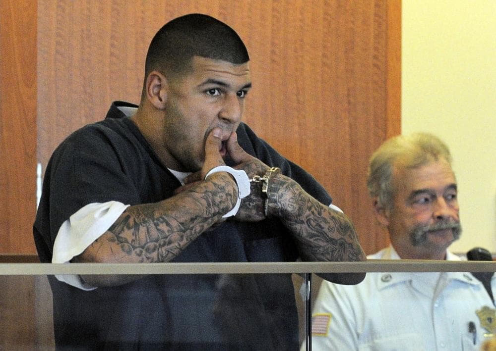 Former New England Patriots football player Aaron Hernandez wipes his mouth while handcuffed during a bail hearing in Fall River Superior Court Thursday, June 27, 2013, in Fall River, Mass. Hernandez, charged with murdering Odin Lloyd, a 27-year-old semi-pro football player, was denied bail. (AP)