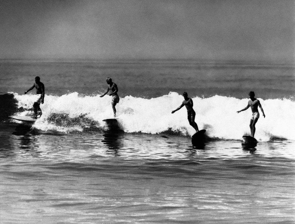 Members of the North Bay surfing club ride the waves at Malibu Beach, California, United States on July 12, 1961, just to enjoy the fun. The sport, enjoyed by some 20,000 people in California, is now being invaded by gangs of truant teenagers who spend all their time on the surf with breaks drinking bouts, sex parties and vandalism, according to the police and local property owners. (AP)