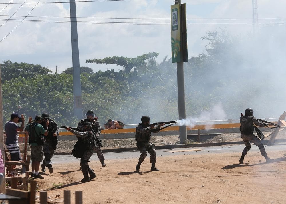 Riot police take positions and fire tear gas toward protesters near the Castelao stadium in Fortaleza, Brazil, Wednesday, June 19, 2013. Protesters cut off the main access road to the stadium where Brazil will play Mexico in the Confederations Cup soccer tournament later Wednesday. Beginning as protests against bus fare hikes, the demonstrations have quickly ballooned to include broad middle-class outrage over the failure of governments to provide basic services and ensure public safety. (AP)