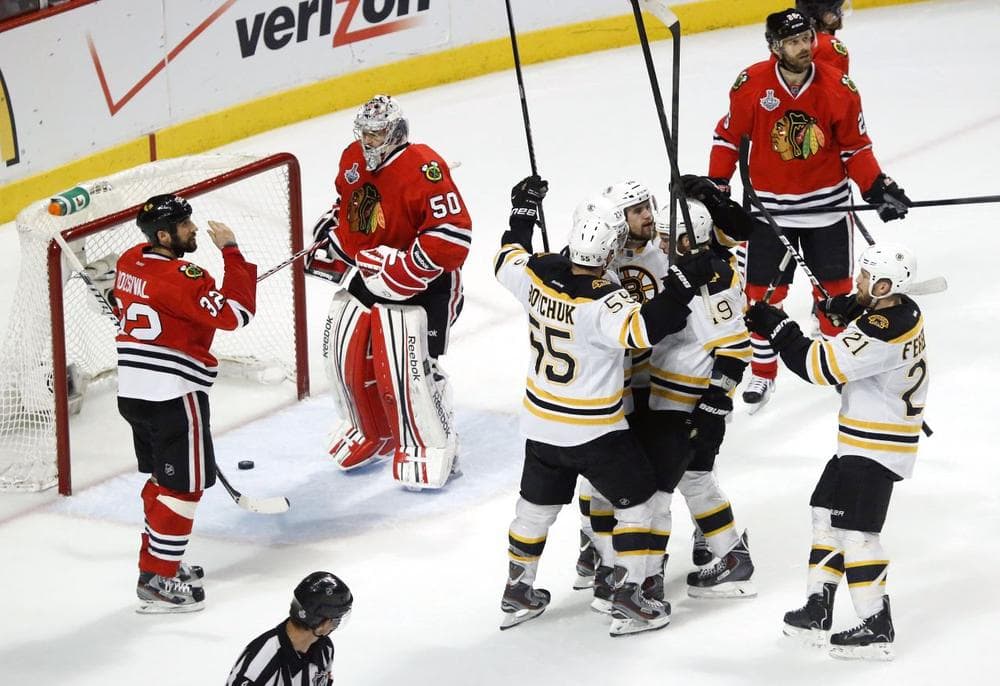 The Boston Bruins celebrate a second-period goal against Chicago Blackhawks goalie Corey Crawford (50) as Chicago Blackhawks defenseman Michal Rozsival (32) watches, Saturday night in Chicago. (Charles Rex Arbogast/AP)