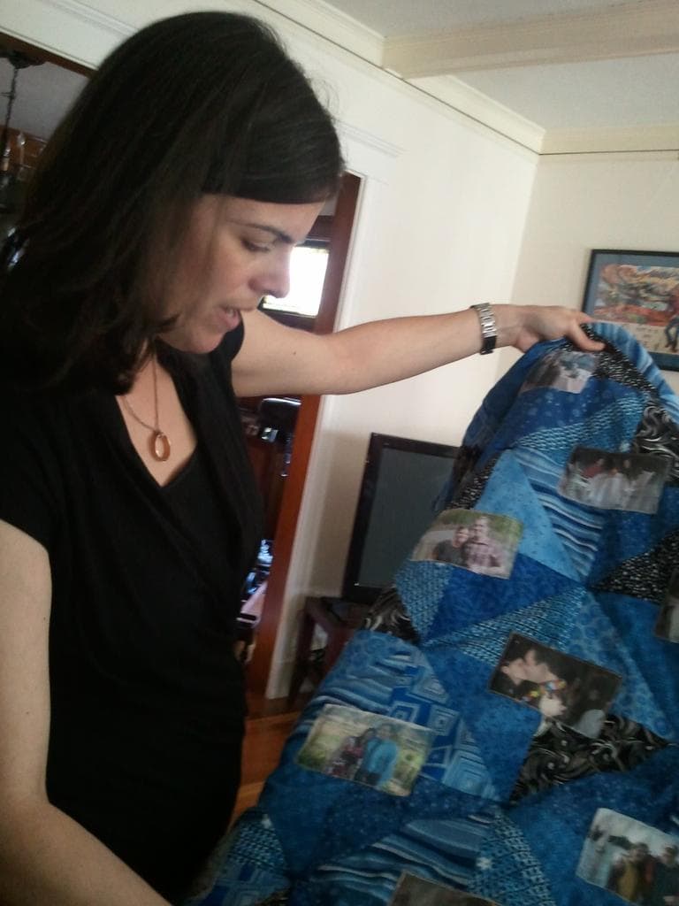 Sara Selig showing quilt made with photos of her late-husband Gregg Stracks