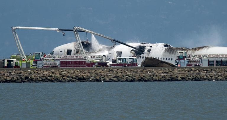 A fire truck sprays water on Asiana Flight 214 after it crashed at San Francisco International Airport on Saturday, July 6, 2013, in San Francisco. (Noah Berger/AP)