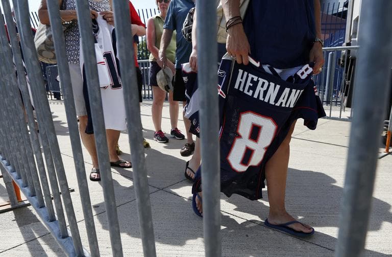 Fans line up behind a barrier to exchange their New England Patriots Aaron Hernandez football jerseys at Gillette Stadium in Foxborough, Mass., Saturday, July 6, 2013. The Patriots are offering a new jersey to all fans who want to get rid of the one they bought with Hernandez's name on it. (Michael Dwyer/AP)