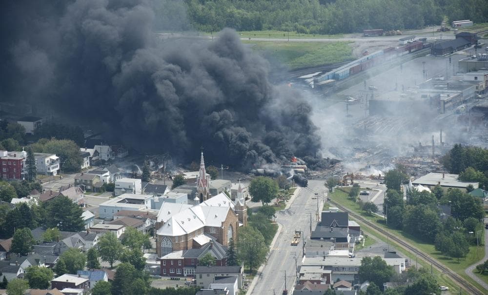 Smoke rises from railway cars that were carrying crude oil after derailing in downtown Lac Megantic, Quebec, Canada, Saturday, July 6, 2013. (Paul Chiasson/The Canadian Press via AP)