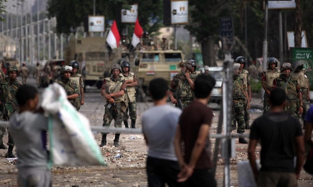 Supporters of ousted President Mohammed Morsi protest as army soldiers guard at the Republican Guard building in Nasr City, Cairo, Egypt, Tuesday, July 9, 2013. (Khalil Hamra/AP)