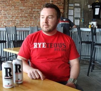 Brian O'Connell of Denver's Renegade Brewing shows off the new design for his renamed beer, Redacted. (Megan Verlee/Colorado Public Radio)