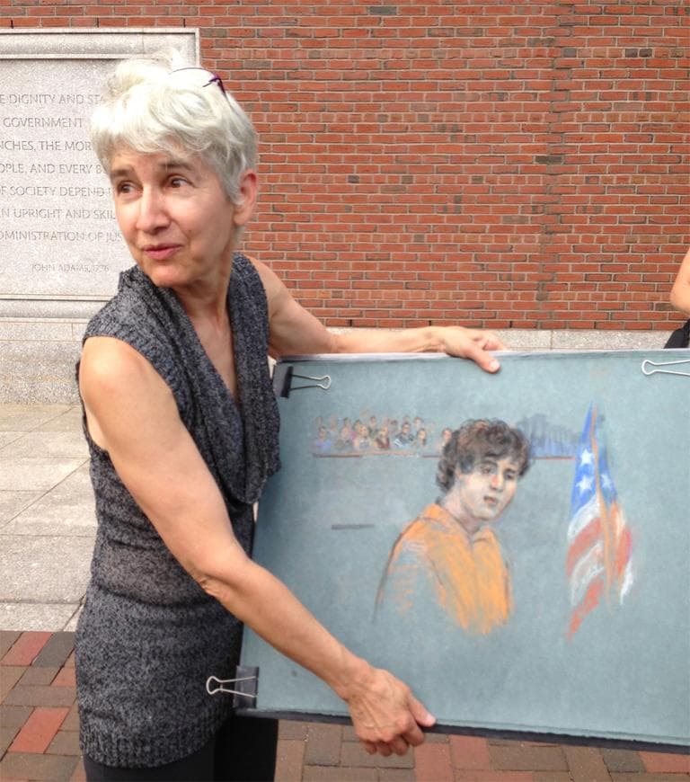 Courtroom sketch artist Margaret Small holding her sketch of alleged Boston Marathon bomber Dzhokhar Tsarnaev. (Bruce Gellerman/WBUR)