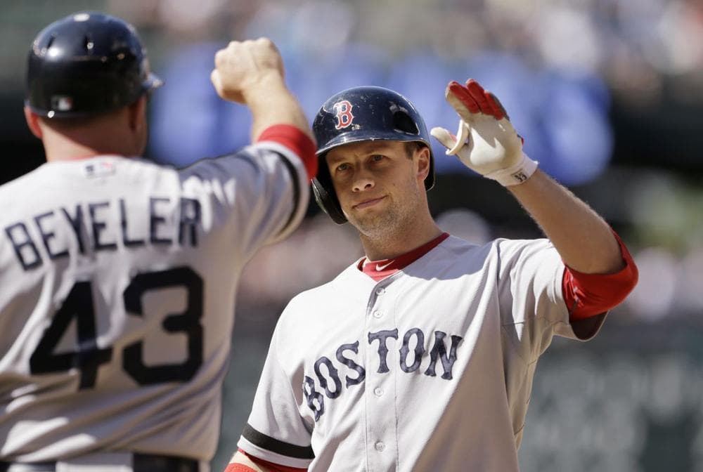 Red Sox's Daniel Nava, right, is congratulated by first base coach Arnie Beyeler after hitting an RBI-single against the Seattle Mariners in the 10th inning. (AP/Elaine Thompson)