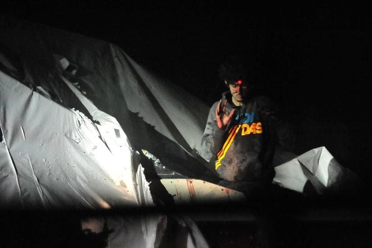 Alleged marathon bomber Dzhokhar Tsarnaev emerges from a boat during his capture. (Courtesy Sgt. Sean Murphy, via Boston Magazine)