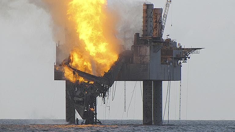In this Wednesday, July 24, 2013 photo released by the U.S. Coast Guard, abatement efforts underway near Hercules 265 Rig where fire has caused collapse of the drill floor and derrick following an explosion Tuesday night. (U.S. Coast Guard via AP)