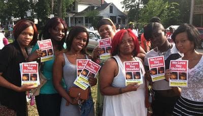 East Cleveland residents hold up flyers of Shirellda Terry at a Friday vigil at 146th &amp; St. Clair (Brian Bull/WCPN)