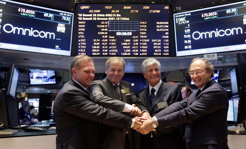 Omnicom Group CFO Randall Weisenburger, left, and President and CEO John Wren, second left, join hands with Publicis Groupe Chairman and CEO Maurice Levy, third left, and CFO Jean-Michel Etienne as they pose for photos on the floor of the New York Stock Exchange Monday, July 29, 2013. (Richard Drew/AP)