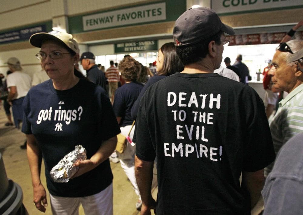 A Red Sox fan, right, passes a Yankees fan, left, at the concession stands at a spring training baseball game in Fort Myers, Fla., Monday, March 14, 2011. (Charles Krupa/AP)