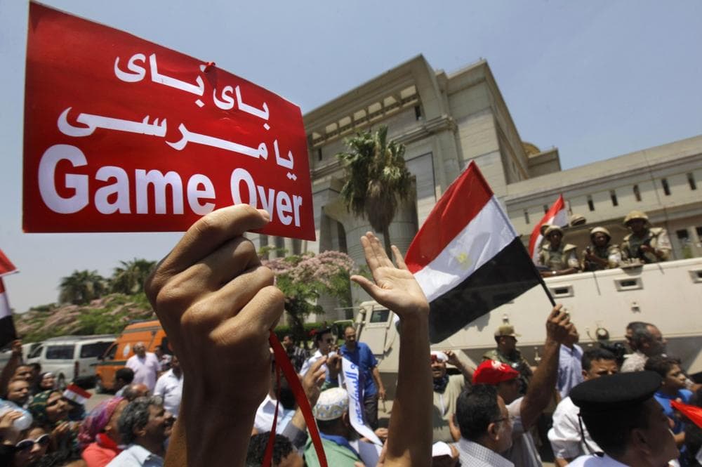 Egyptians celebrate in front of the constitutional court after Egypt's chief justice Adly Mansour was sworn in as the nation's interim president Thursday, July 4, 2013. Arabic reads, &quot; bye bye Morsi.&quot; (AP)