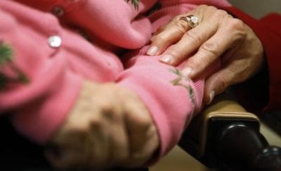 Alexis McKenzie, right, executive director of The Methodist Home of the District of Columbia Forest Side, an Alzheimer’s assisted-living facility, puts her hand on the arm of resident Catherine Peake, in Washington, Feb. 6, 2012. (Charles Dharapak/AP)