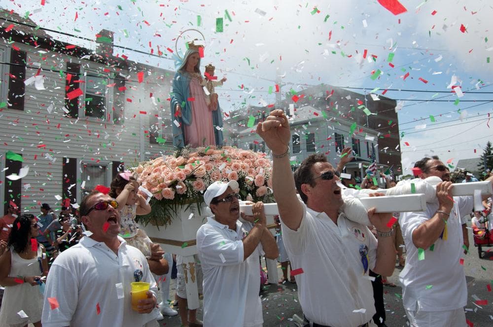 Men carrying the Mother of Grace statue shout blessings on Prospect Street during Sunday’s procession. (Greg Cook)
