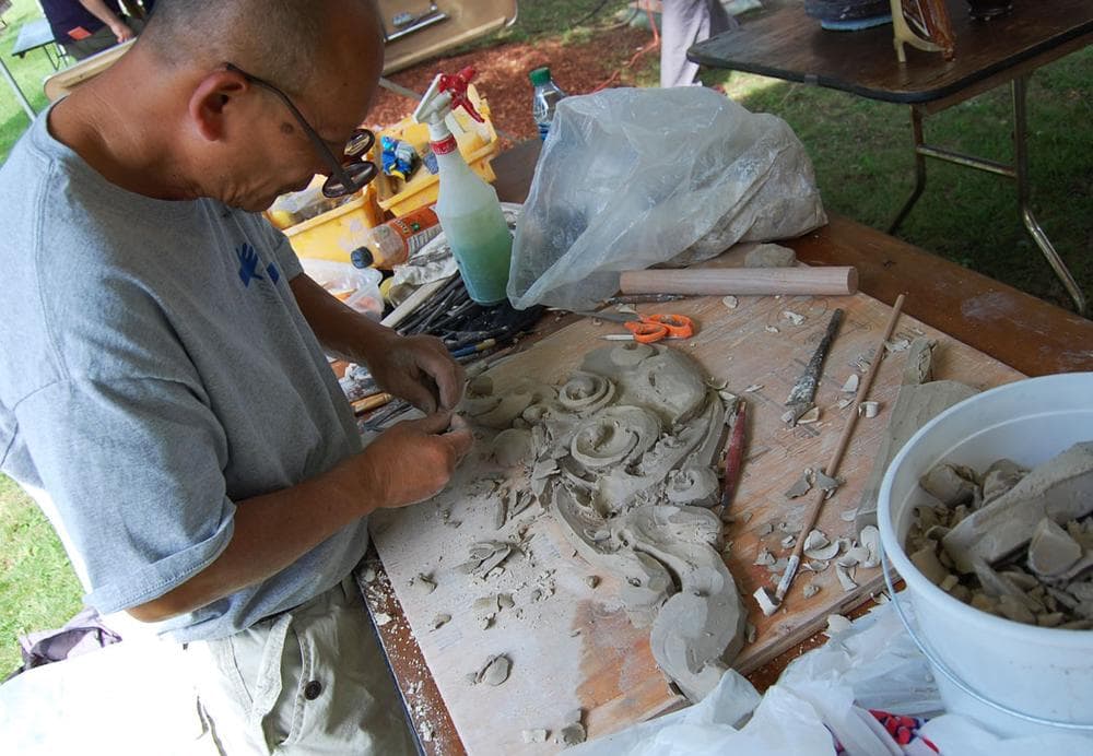 In Cambodia, they call this shape the lotis flower shape,” says Yary Livon of Lowell, who was molding white clay into Khmer architectural decorations. “It looks like vines when they grow.” (Greg Cook)