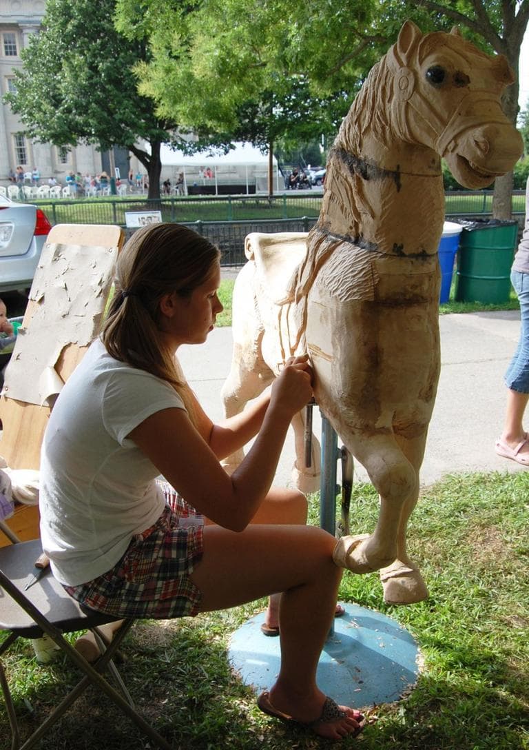 I saw [a carousel horse] at the state Augusta show and it won best in show. Thirteen-year-old me decided to have big ambitions and do it,” says Ellyzabeth Bencivenga of Limestone, Maine, who has been carving her full-sized carousel horse for three years now. She says the project has taught her “patience.” (Greg Cook)