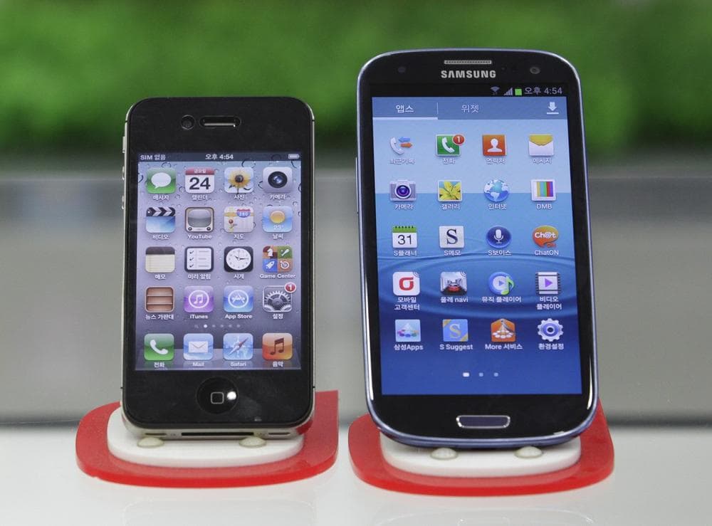 Samsung Electronics' Galaxy S III, right, and Apple's iPhone 4S are displayed at a mobile phone shop in Seoul, South Korea. (Ahn Young-joon/ AP)