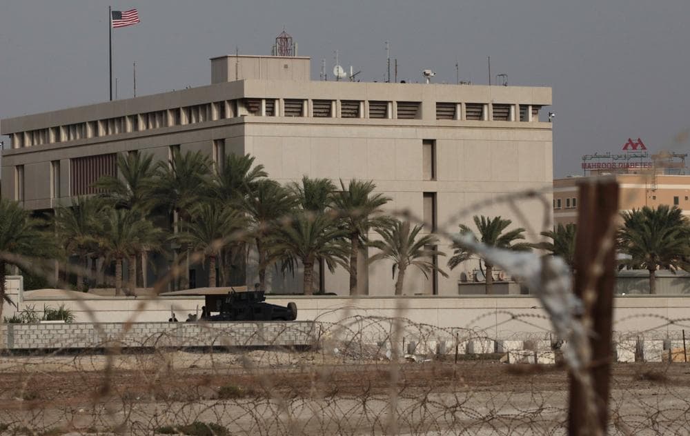 A Bahraini armored personnel vehicle and personnel reinforce U.S. Embassy security just outside of a gate to the building, surrounded in barbed wire, in Manama, Bahrain, on Sunday, Aug. 4, 2013. (Hasan Jamali/AP)