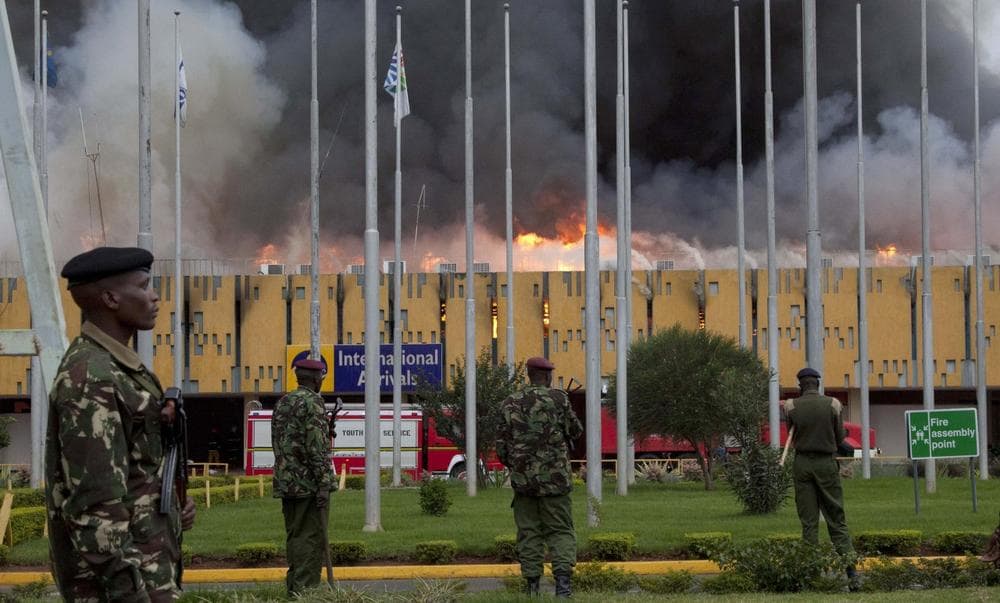 Police stand guard as fire engulfs the International arrivals unit of Jomo Kenyatta International Airport, Nairobi, Kenya, Wednesday Aug. 7, 2013. (Sayyid Azim/AP)