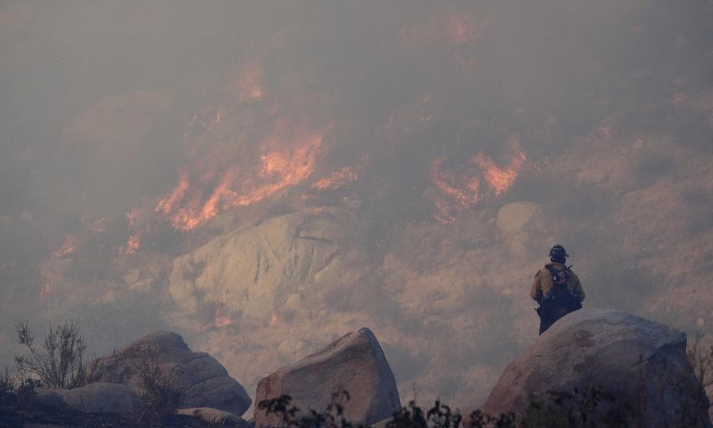 A firefighter watches a backfire burn while battling a wildfire, Thursday, Aug. 8, 2013, in Banning, Calif. (Jae C. Hong/AP)