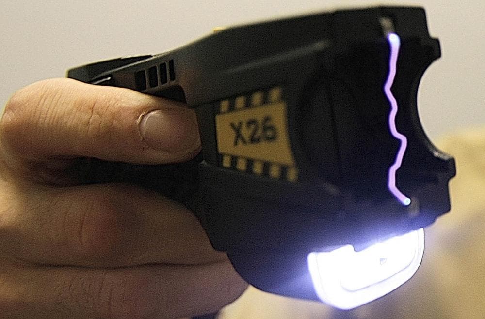 An electrical arc glows at the end of a Taser. (Toby Talbot/AP)