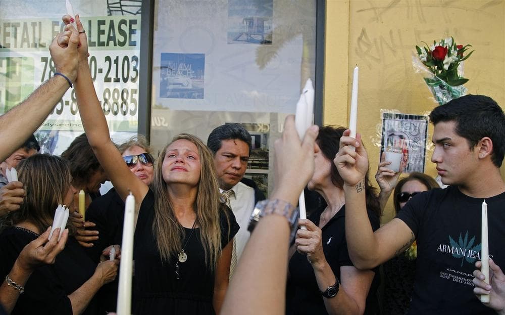 Offir Hernandez, third from left, the sister of Israel Hernandez-Llach, leads a group of mourners in holding candles to the sky in memory of her brother. Family members, friends, schoolmates and fans gathered at in Miami Beach for a vigil on Thursday, Aug. 8, 2013. (Carl Juste/Miami Herald)