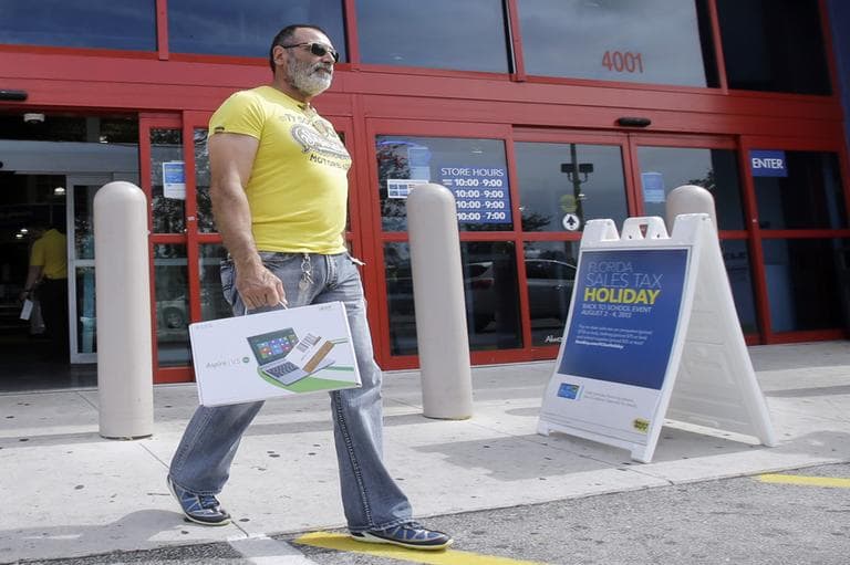 Fidel Deesa walks out of a Best Buy store with a new laptop, taking advantage of the back-to-school sales tax holiday, in Hialeah, Fla. (Alan Diaz/AP)