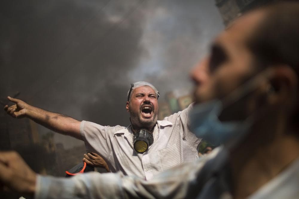Supporters of ousted Islamist President Mohammed Morsi shout during clashes with Egyptian police at the Rabaah Al-Adawiya protest camp in Cairo's Nasr City district, Egypt, Wednesday, Aug. 14, 2013. (Manu Brabo/AP)