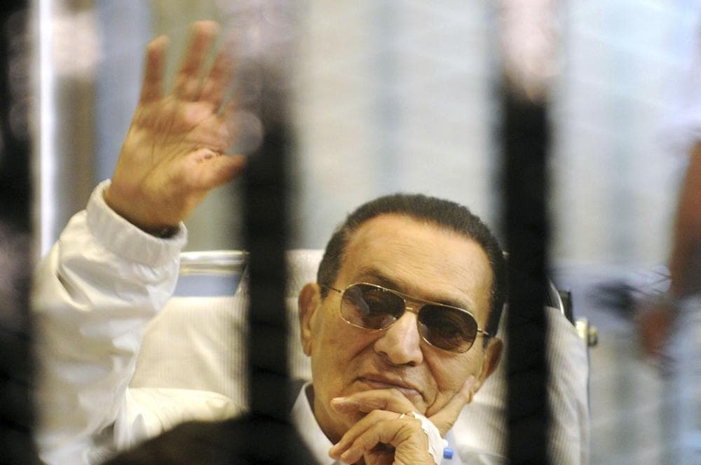 In this April 13, 2013, photo, former Egyptian President Hosni Mubarak waves to his supporters from behind bars as he attends a hearing in his retrial on appeal in Cairo, Egypt. (AP)