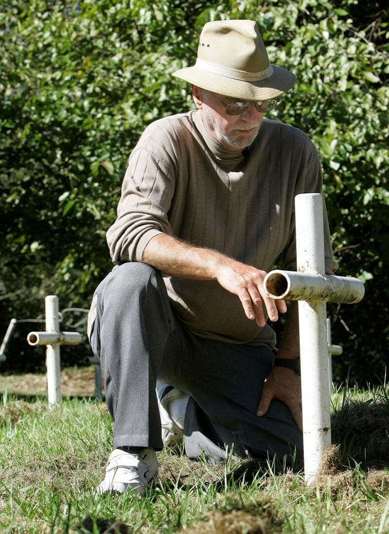 Roger Kiser kneels at the grave of a fellow inmate at the Aurthur G. Dozier School for Boys following ceremonies dedicating a memorial to the suffering of the White House Boys, Oct. 21, 2008, in Marianna, Fla. (Phil Coale/AP)