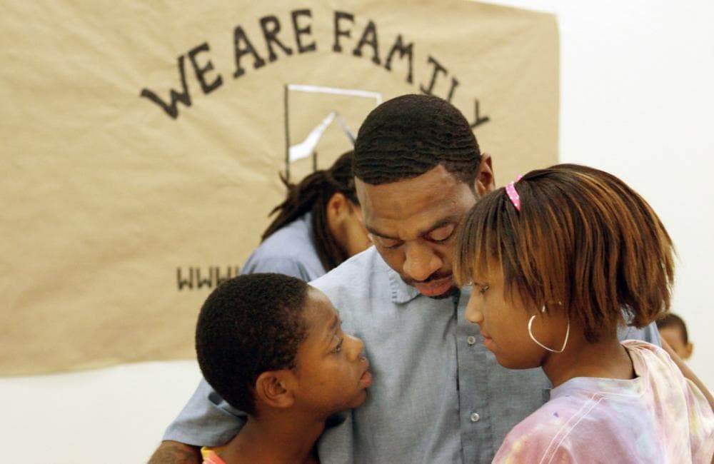 Geray Williams, an inmate at the North Branch Correctional Institution in Cumberland, Md., says goodbye to his children, Sanchez, 12, and Summer Williams, 13, during the closing minutes of a weeklong summer day camp at the maximum security prison, July 30, 2010. (Timothy Jacobsen/AP)
