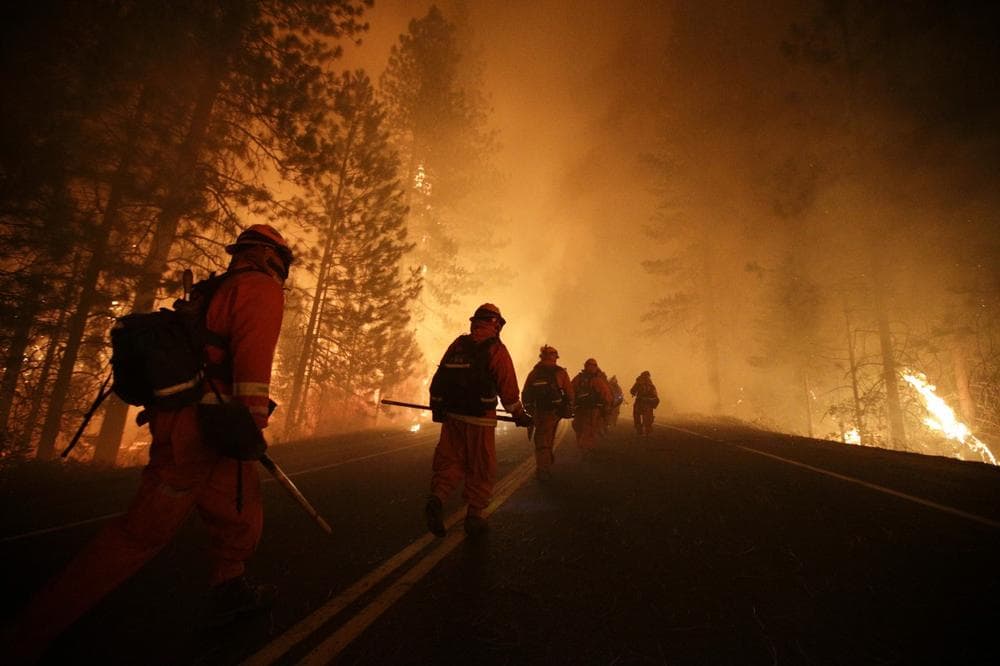 Inmate firefighters walk along Highway 120 as firefighters continue to battle the Rim Fire near Yosemite National Park, Calif., on Sunday, Aug. 25, 2013. Fire crews are clearing brush and setting sprinklers to protect two groves of giant sequoias as a massive week-old wildfire rages along the remote northwest edge of Yosemite National Park. (Jae C. Hong/AP)