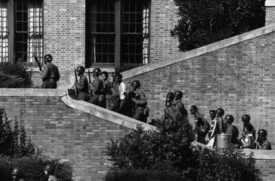 Members of the Little Rock Nine are escorted into Central High School, in 1957. They were the first black children to attend the all-white school. (Wikipedia)