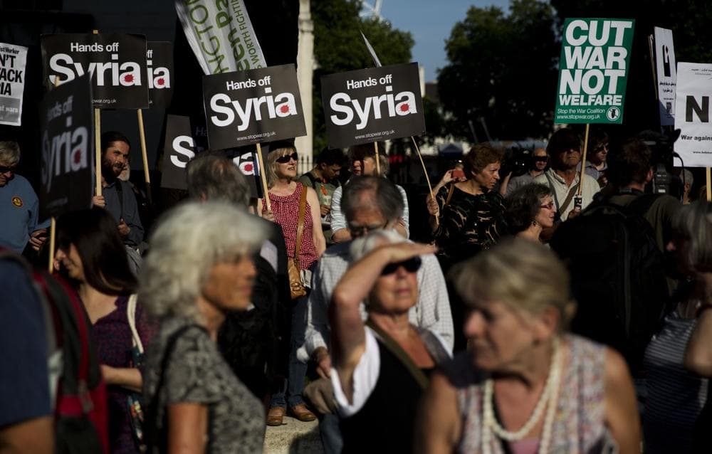 People take part in a protest organized by the Stop the War coalition calling for no military attack on Syria from the U.S., Britain or France, across the road from the entrance of Downing Street in London, Wednesday, Aug. 28, 2013. (Matt Dunham/AP)