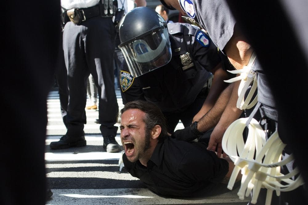 Occupy Wall Street protestor Chris Philips screams as he is arrested near Zuccotti Park, Monday, Sept. 17, 2012, in New York. Multiple Occupy Wall Street protestors have been arrested during a march toward the New York Stock Exchange on the anniversary of the grass-roots movement. (AP Photo/John Minchillo)